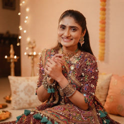 Kavya Nair wearing a digital print muslin lehenga set in a festive, naturally lit portrait.